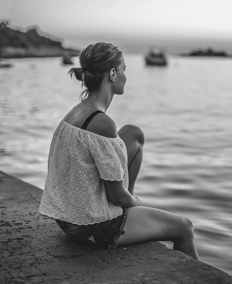 Woman sitting on seaswall